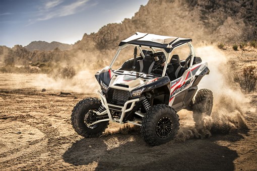 Three-quarter front angle of a person making a sharp turn in a side x side off-road. opens in a new window