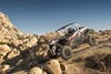 Three-quarter front angle of a person driving a side x side off-road.