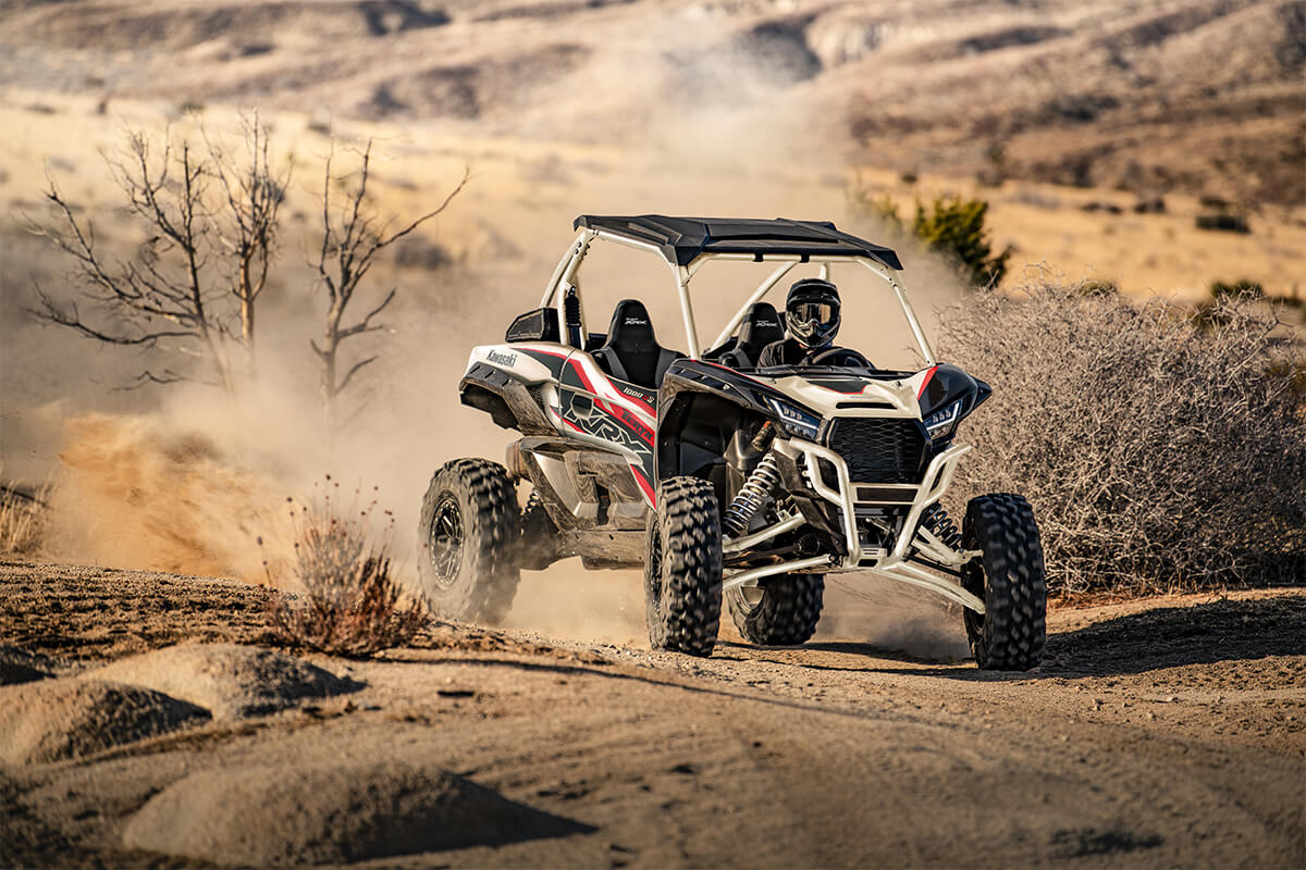 Three-quarter front angle of a person coming out of a turn in a side x side off-road.