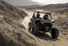 Three-quarter front angle of a side x side driving off-road.