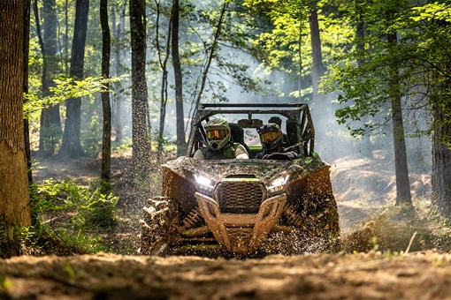 Front angle of a side x side driving in mud. opens in a new window