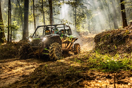 Three-quarter front angle of a side x side driving in the forest. opens in a new window