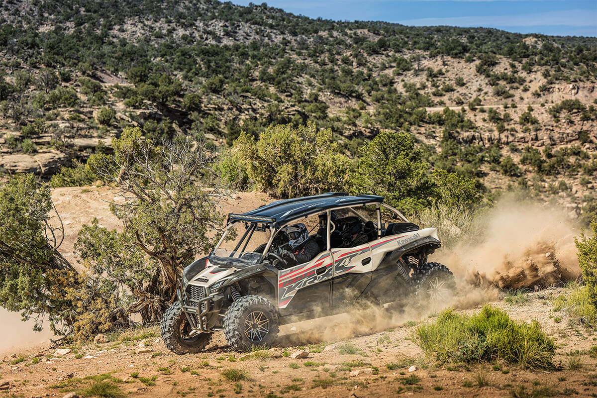 Three-quarter front angle of a person driving a side x side off-road.