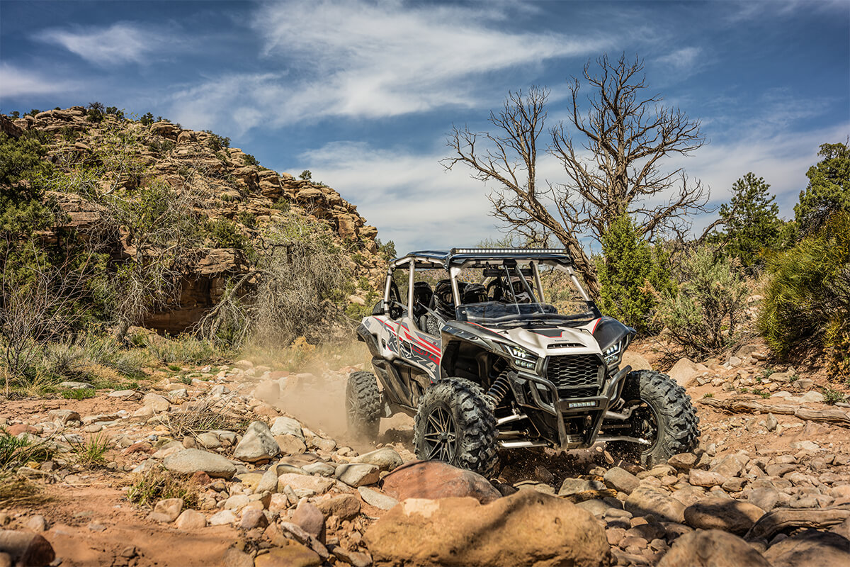 Three-quarter front angle of a person making a turn in a side x side off-road.