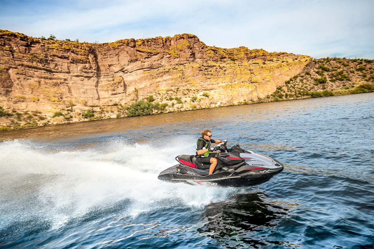 Side angle of a person on a personal watercraft on the water.