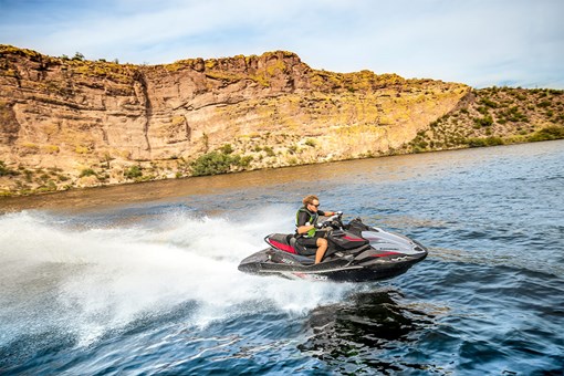 Side angle of a person on a personal watercraft on the water. opens in a new window