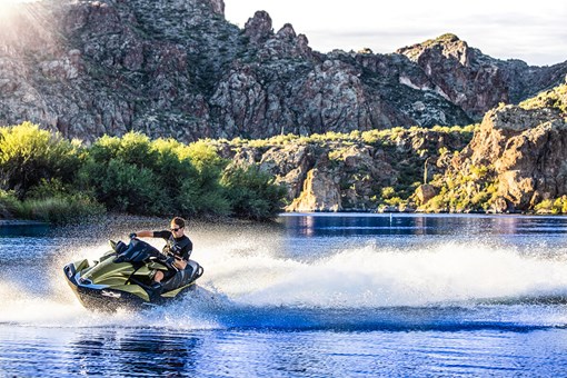 Three-quarter front angle of a person on a personal watercraft making a sharp turn on the water. opens in a new window