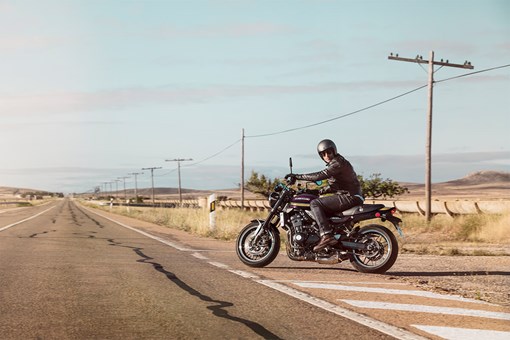  Side angle of a person riding a motorcycle on a rural street. opens in a new window