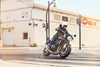 Three-quarter front angle of a person riding a motorcycle on a rural street.