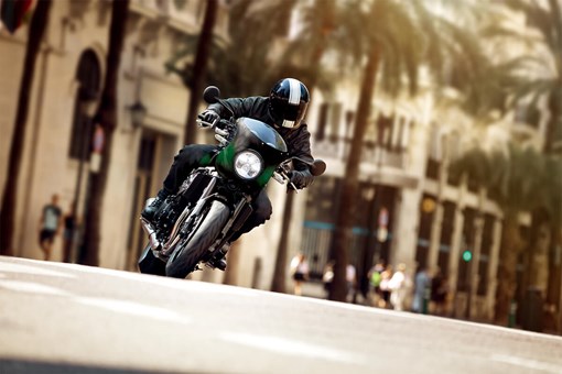 Front angle of a person riding a motorcycle on a city street. opens in a new window