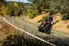 Three-quarter front angle of a person riding a motorcycle on a highway.