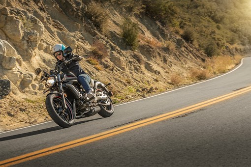 Side angle of a person riding a motorcycle on a highway. opens in a new window