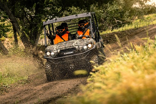 Front angle of a person driving a side x side off-road with passengers. opens in a new window