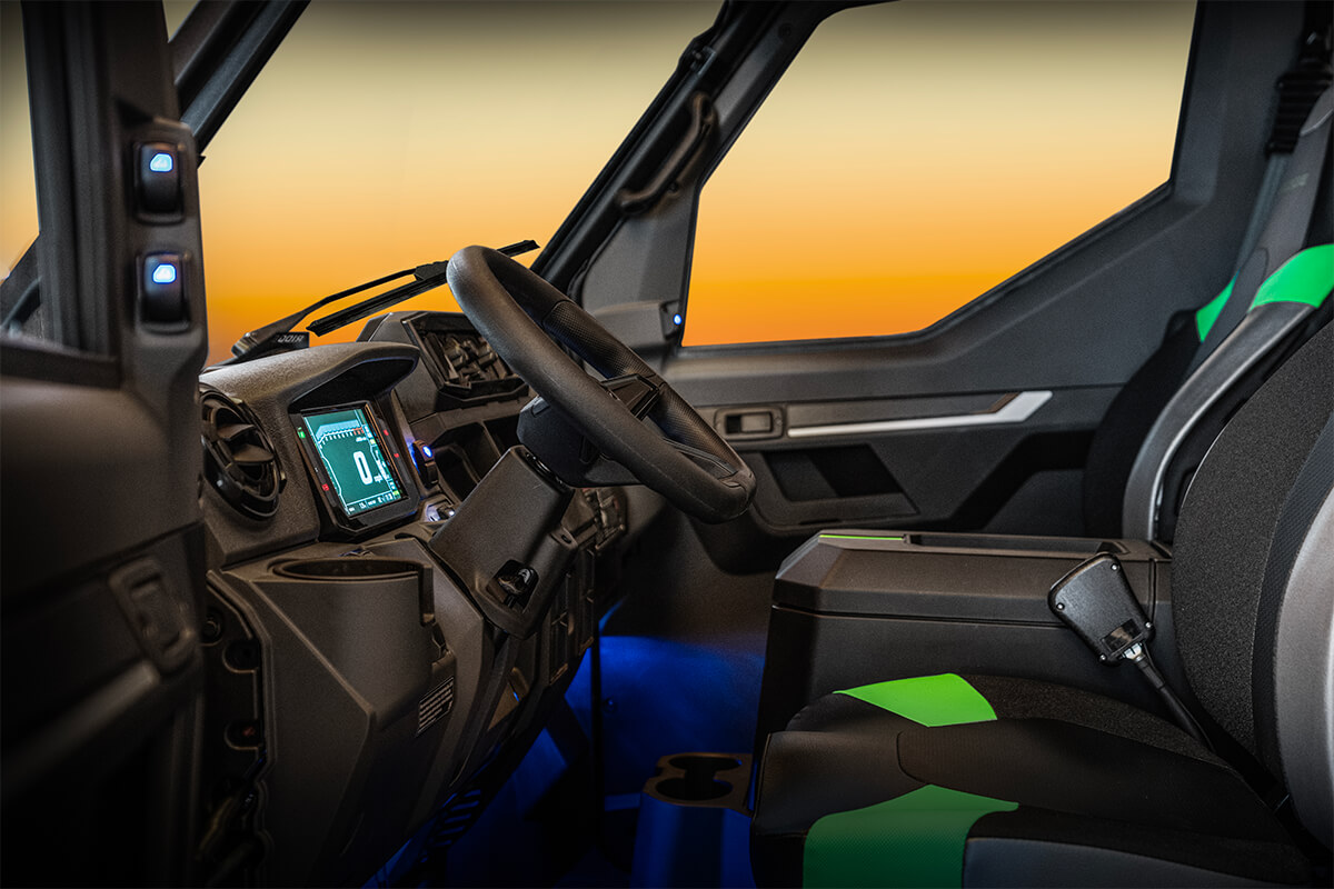 Close up side view of the interior driver seat and controls of a side x side.