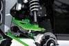 Close-up view of the shock and A-arm of a side x side staged in a white studio background.