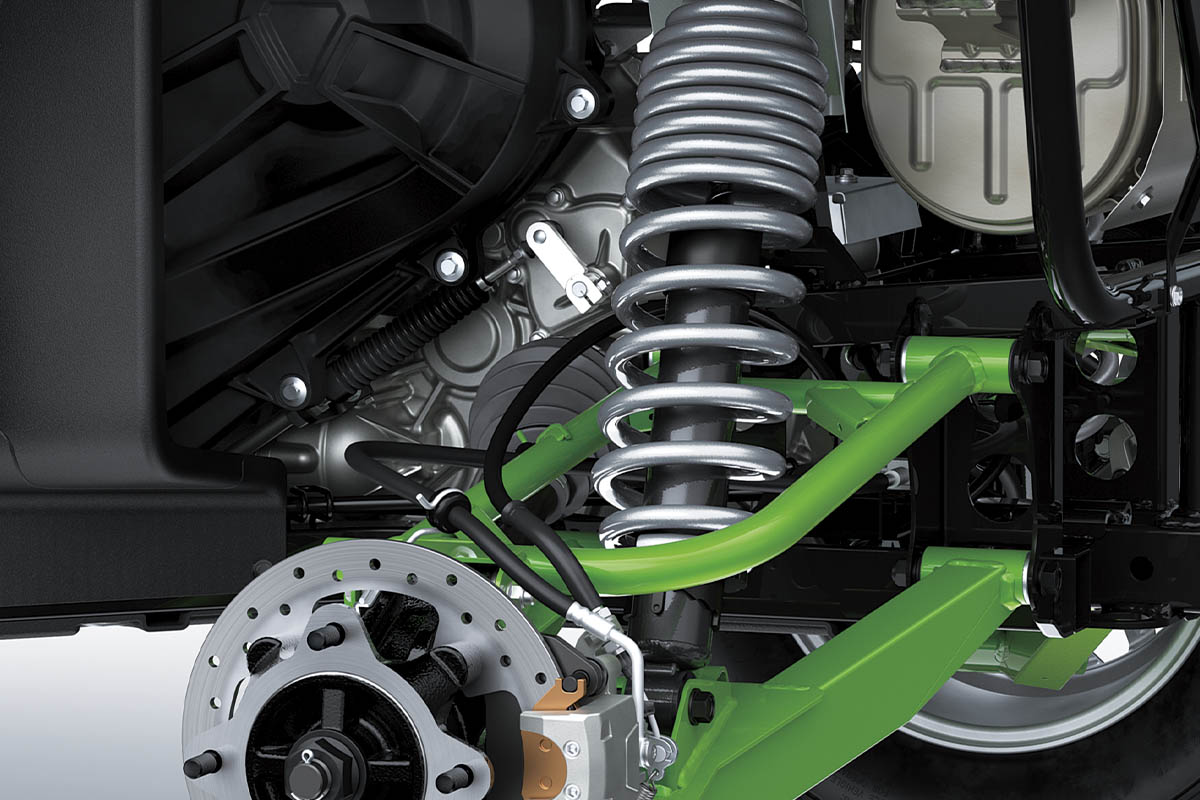 Close-up view of the shock and A-arm of a side x side staged in a white studio background.