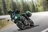 Three-quarter front angle of a person riding a motorcycle on a scenic highway.
