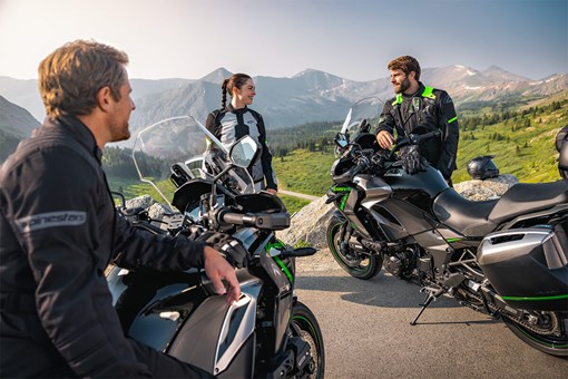 Two motorcycles parked at a scenic overlook with people standing nearby. opens in a new window