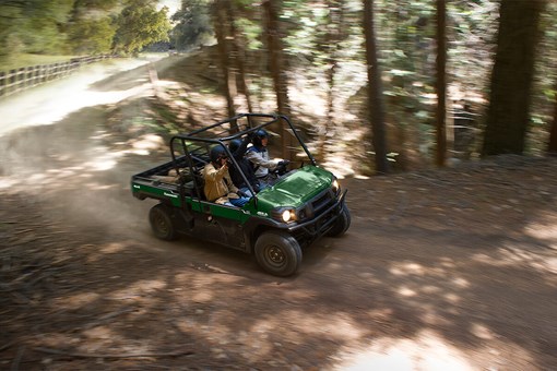 Three-quarter front angle of a person driving a side x side off-road. opens in a new window