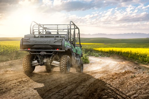 Three-quarter rear angle of a person driving a side x side off-road. opens in a new window