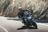 Three-quarter front angle of a person riding a motorcycle in the mountains.