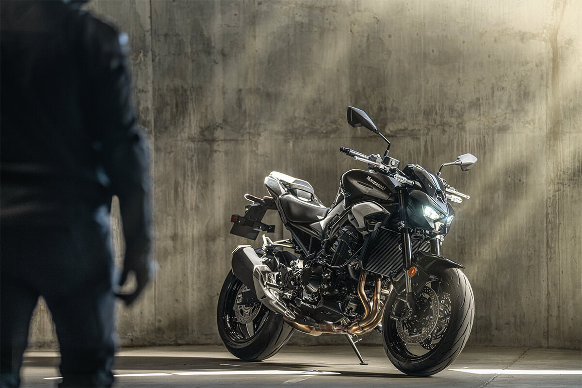 Profile angle of a motorcycle staged in front of a cement wall.