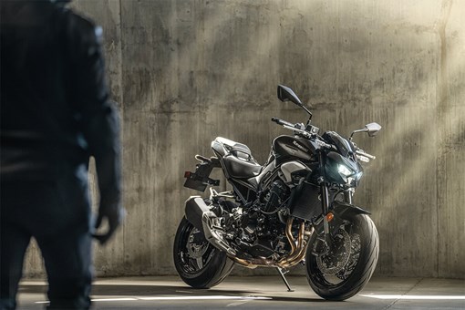 Profile angle of a motorcycle staged in front of a cement wall. opens in a new window