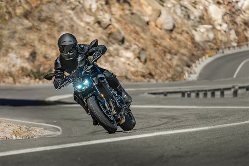 Front angle of a person riding a motorcycle in the mountains. opens in a new window