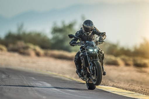 Front angle of a person riding a motorcycle on a track. opens in a new window