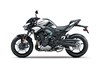 Profile angle of a silver motorcycle staged in a studio.