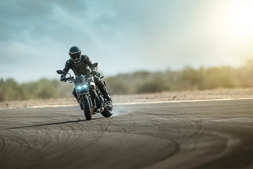 Front angle of a person sliding the back tire of a motorcycle on the track. opens in a new window