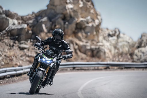Front angle of a person riding a motorcycle in the mountains. opens in a new window