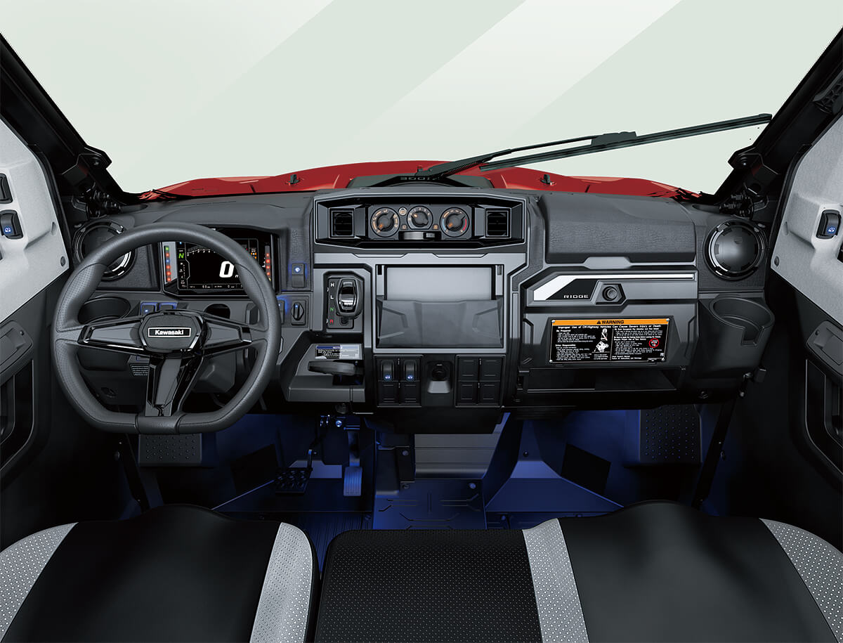 Interior cabin view of the front dash and controls of a side x side with floor accent lighting.