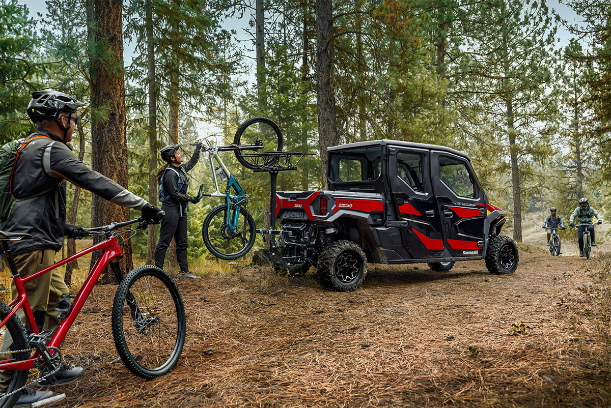 Rear three-quarter view of a side x side with a mountain bike mounted on the back.