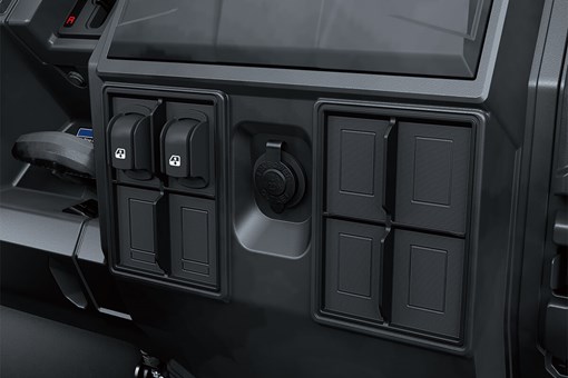 Interior dash of a side x side showing accessory switches and 12V power outlet. opens in a new window