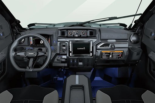 Interior cabin view of the front dash and controls of a side x side with floor accent lighting. opens in a new window
