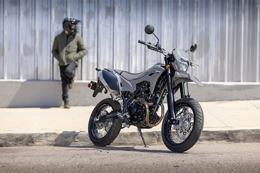 Front three-quarter view of a parked motorcycle with a person in the background. opens in a new window