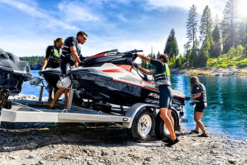 People unloading a personal watercraft from a trailer into the water.  opens in a new window