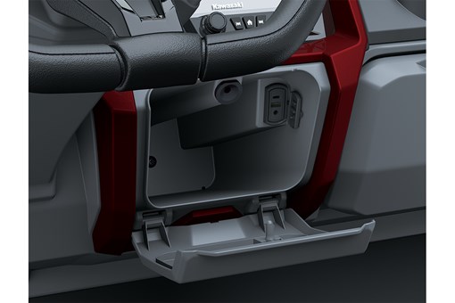 Close-up view of a charging port and storage compartment in a Neighborhood Activity Vehicle. opens in a new window