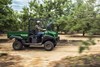 Side angle of a person driving a side x side on a ranch.