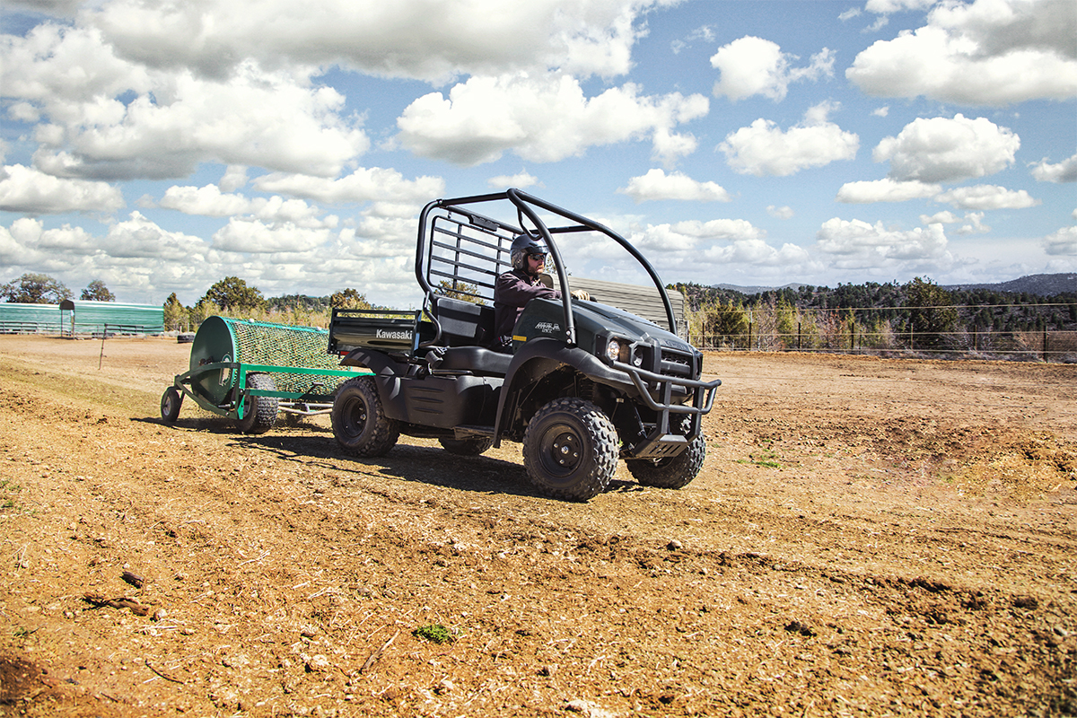 Three-quarter front angle of a person driving a side x side on a ranch.