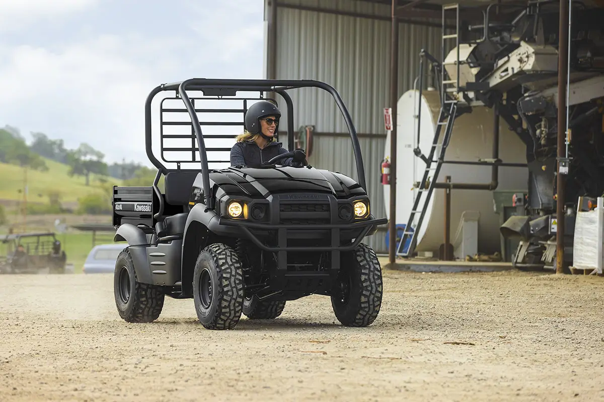 Front angle of a person driving a side x side on a ranch.
