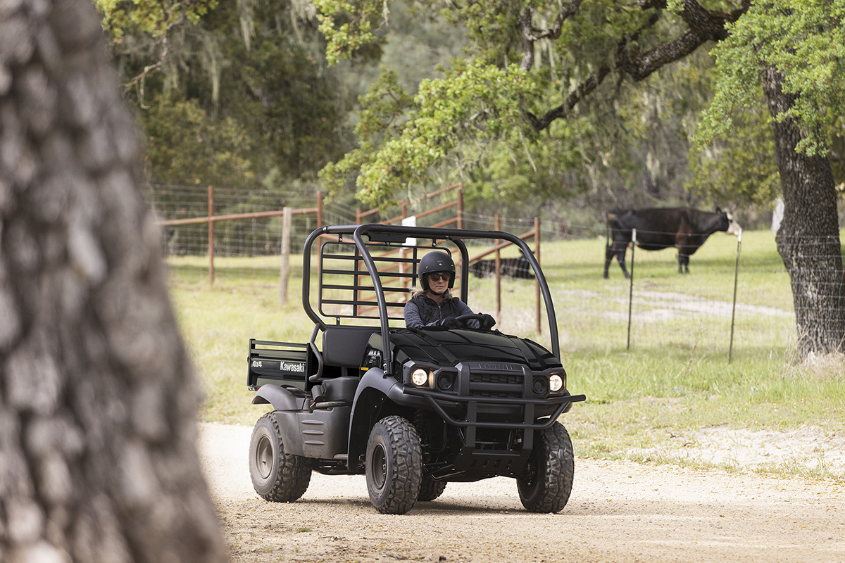 Three-quarter front angle of a person driving a side x side on a ranch.