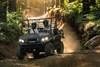 Front angle of two people riding a side x side off-road.