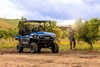 Three-quarter front angle of a blue side x side parked off-road.