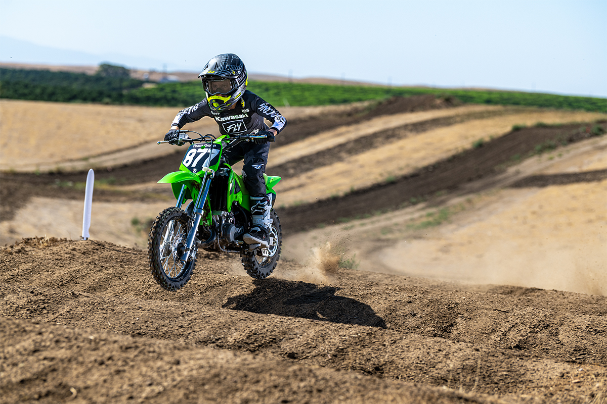 Three-quarter front angle of a person riding a motorcycle on a dirt track.