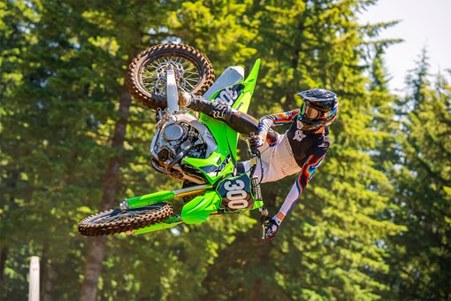 Side angle of a person riding a motorcycle, whipping in midair. opens in a new window