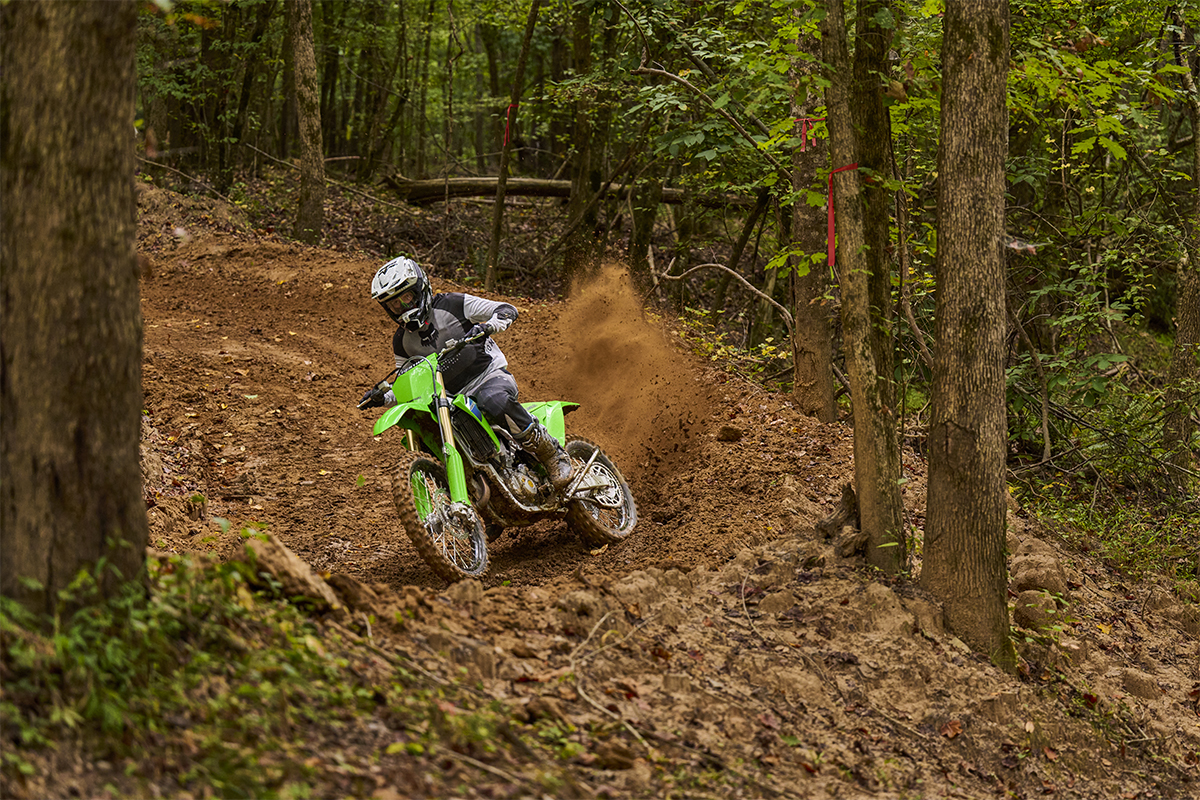 Three-quarter front angle of a person riding a motorcycle on an off-road course.