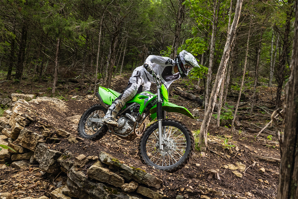Side angle of a person riding a motorcycle off-road.