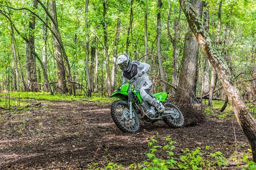 Three-quarter front angle of a person riding a motorcycle off-road. opens in a new window